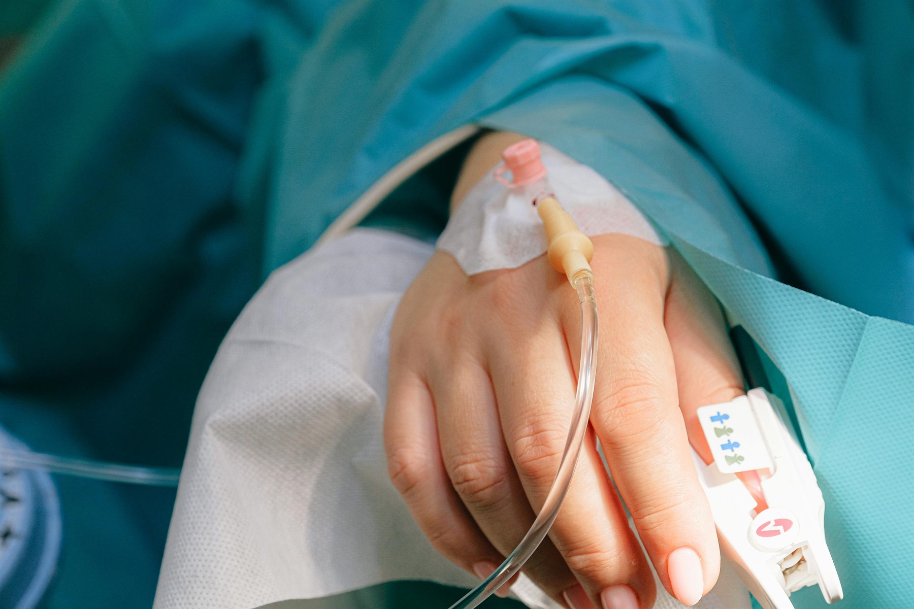 Patient with IV line in a clinical care setting.