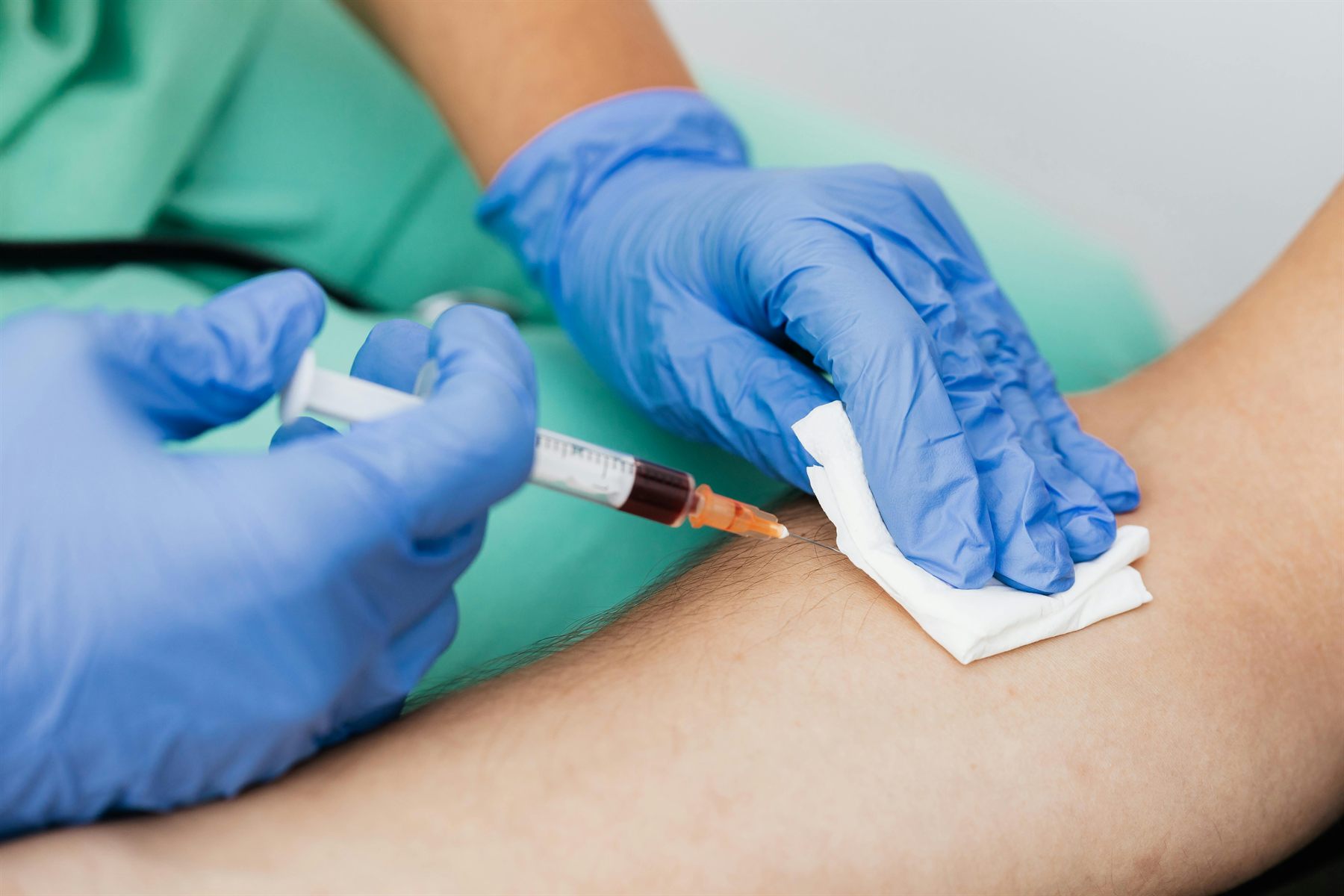 Clinical venipuncture procedure close-up.